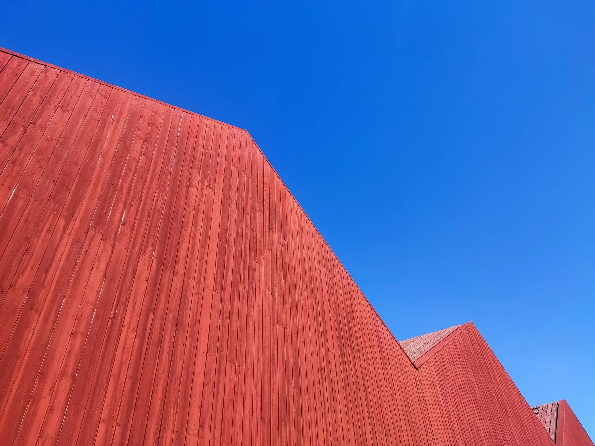 Just a red painted wooden wall and the blue sky.