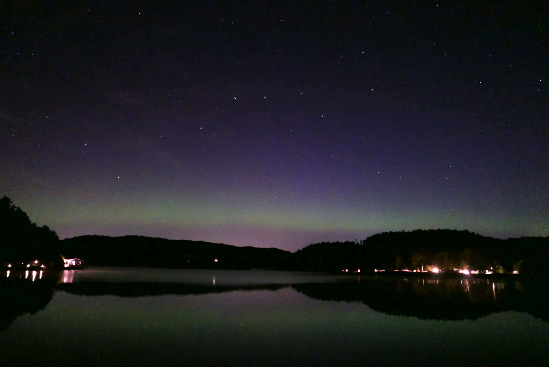 a picture of a night sky with a aurora borealis, reflected on a lake.